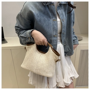 Détail du sac cabas en paille tressée avec poignées en cuir marron et design trapèze beige