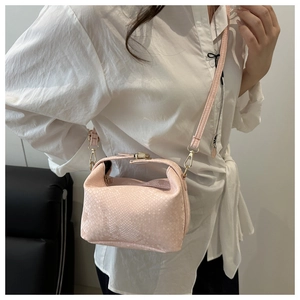 Detail of light pink snake-patterned leather crossbody bag with gold metallic buckle