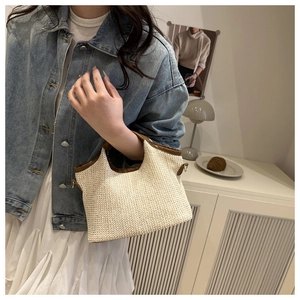 Détail du sac cabas en paille pour femme avec bordure en cuir marron sur un mannequin