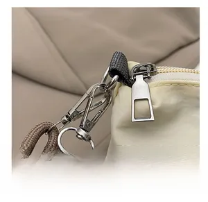 Detail of high-quality silver metal hook and zipper on beige cat embroidery bag