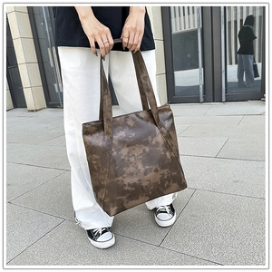 Detail of vintage brown tote bag showing retro textured faux leather in outdoor setting