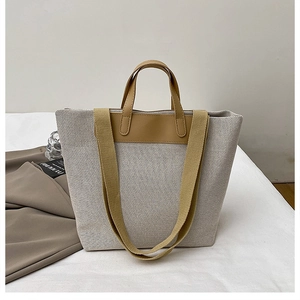 Detail of canvas tote bag showing wide bottom space and leather handles with straps