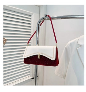 Close-up of contrast color handbag featuring gold stitching and red sequin textures