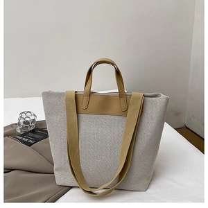 Detail view of large canvas tote bag with leather trim and mustard shoulder strap