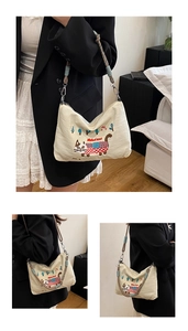 Close-up of cat embroidery on beige canvas tote bag with braided rope strap detail