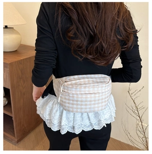 Gros plan du sac banane à carreaux beige montrant la texture et la fermeture éclair