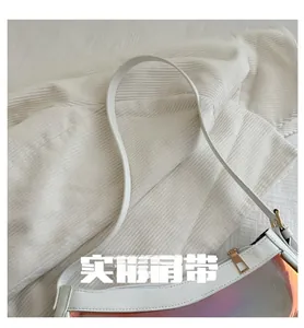 Detail of white leather shoulder bag with iridescent laser panel and gold zipper hardware