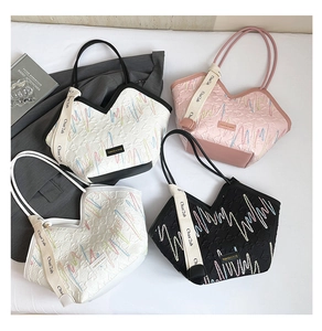 Detail of four colorful tote bags with wavy embroidery and textured diamond patterns