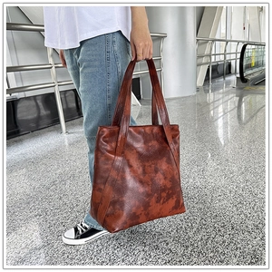 Brown vintage distressed leather tote bag with large capacity for women shown by a model