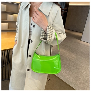 Borsa hobo chic in vernice verde neon indossata con un classico trench beige per l'autunno