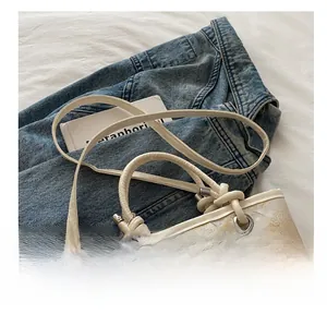 Detail of floral tote bag with rope handle and adjustable strap on denim background