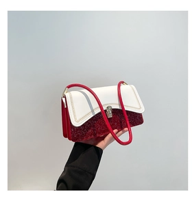 Close-up of red sequin handbag featuring white leather flap and gold buckle closure