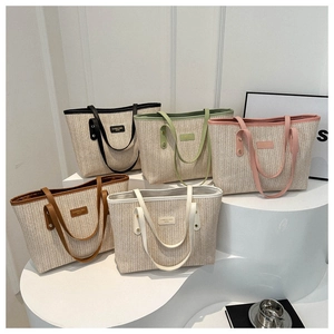 Minimalist straw tote bags in five colors displayed on white curved stairs display
