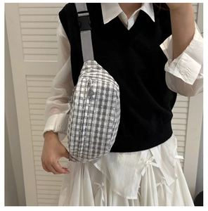 Detail showing grey plaid corduroy waist bag with floral accents and adjustable strap