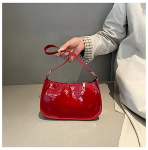 Dettaglio della borsa a spalla in vernice rossa con finitura lucida e cerniera dorata
