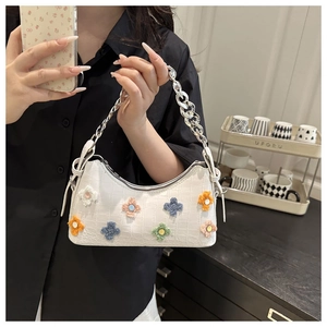 White croc-textured baguette bag with colorful plush flowers and silver chain strap