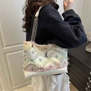 Star-pattern denim tote bag with frayed edges, gold chain strap and deer charm