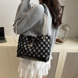 Classic black and white checkered tote bag with leather base and gold deer charm