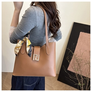 Detailansicht der braunen Leder-Tote-Bag mit goldener Schnalle und dekorativem Seidenschal