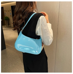 Primo piano della borsa hobo in vernice azzurra con finitura lucida e tracolla alla moda