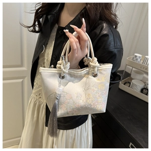 Detail of embroidered floral patterns and tassel pendant on the New Chinese bucket bag