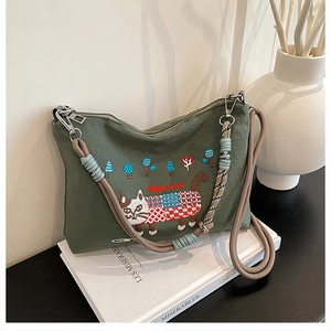 Detail of green canvas tote bag with cat embroidery and thick woven rope handle