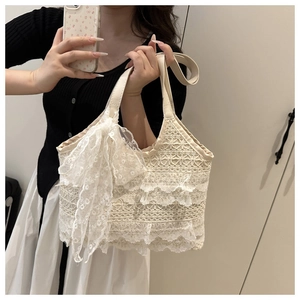 Détail du sac cabas en dentelle crème avec volants superposés et nœud décoratif