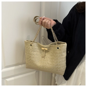 Dettaglio borsa tote in paglia beige con trama a V e manico a catena dorata