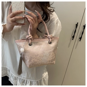 Detail of pink satin bag featuring traditional Chinese embroidery and long silk tassel