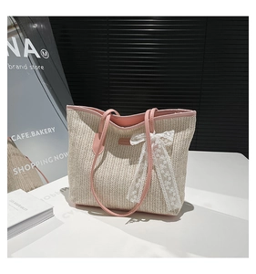 Détail du sac en paille avec bordure en cuir rose et un nœud délicat en dentelle blanche