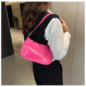 Vista laterale dettagliata di una borsa a spalla in pelle verniciata rosa con zip dorata