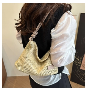 Détail du sac en paille tressé beige avec bandoulière à nœud et étiquette logo d'été