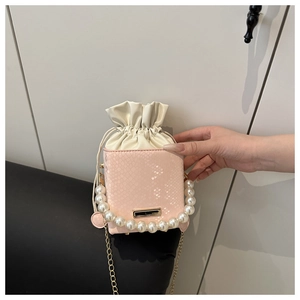 Detailed shot of pink snakeskin texture bucket bag with faux pearl handle and gold chain