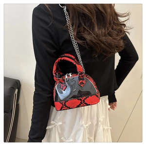 Dettaglio della mini borsa a conchiglia pitonata con PVC trasparente e catena su modella