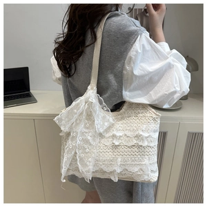 Détails des volants en dentelle et du grand nœud sur ce sac à bandoulière crème élégant