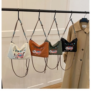 Detail of four colorful canvas tote bags with cat embroidery and adjustable straps