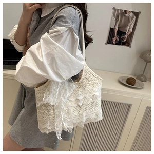 Détail du sac à bandoulière en dentelle crochetée crème avec un grand nœud décoratif élégant