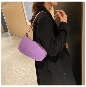 Vista dettagliata di una borsa baguette in pelle PU viola indossata da una modella in corridoio