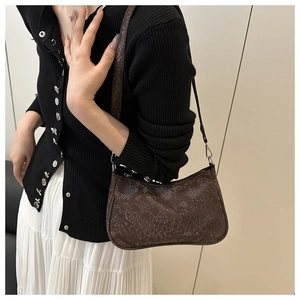 Détail du motif peau de serpent marron foncé sur un sac demi-lune tendance à l'épaule