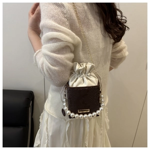 Detail of snake pattern mini bucket bag with pearl handle and metal chain strap