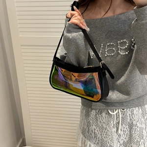 Detail of a black leather shoulder bag featuring a vibrant holographic laser transparent panel