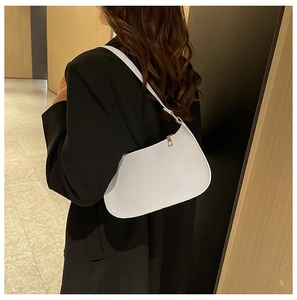 Dettaglio borsa hobo bianca minimalista con finitura opaca e dettagli in oro