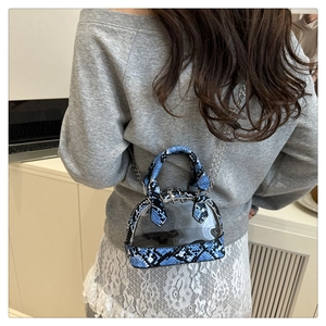 Vista posteriore della modella con borsa a conchiglia in PVC trasparente e trama serpente