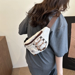 Minimalist white nylon chest bag with brown contrast straps shown on female model back