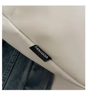 Close-up of premium white leather texture with FANYISSA brand label and precision stitching