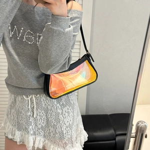 Detailed close-up of holographic transparent shoulder bag with black leather trim detail