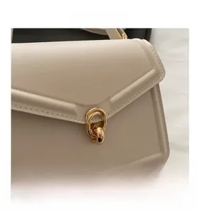 Detail shot of elegant beige handbag featuring premium golden double-ring metal buckle