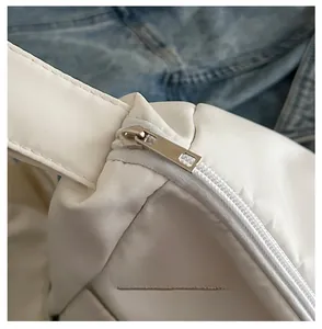 Detailed macro view of the smooth white zipper and silver metal slider on canvas bag