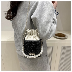 Detail of snake pattern bucket bag with large pearl handle and drawstring inner pouch