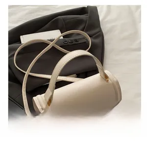 Detailed top view of a cream rectangular handbag with gold hardware and adjustable strap